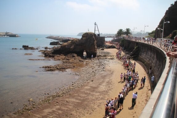 Los candasinos formaron una cadena humana entre la playa de La Pregona y el espigón de Palmera como protesta al plan de ampliación. 