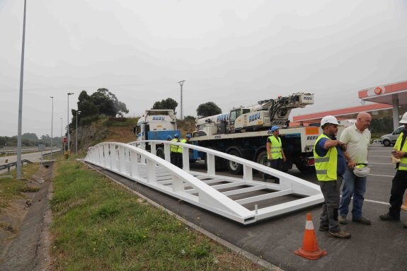 Instante en el que los operarios de la obra depositaban la estructura de la pasarela en la gasolinera de la autovía del Cantábrico, en Posada, hace ya doce días. 