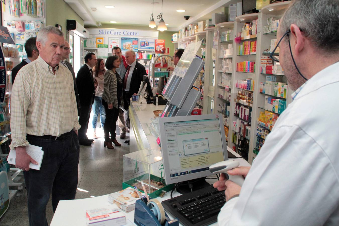 Clientes en una farmacia de Luanco.