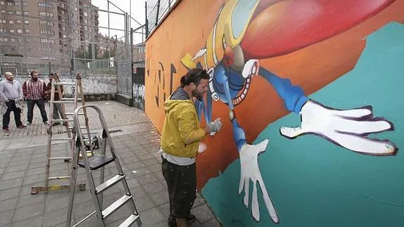 Varios de los grafiteros que iban a actuar en Cimadevilla, pintando sobre un muro de Fortuna Balnearia, en Laviada.