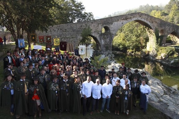 Las cofradías asistentes al IV Capítulo y los cocineros estrella Michelin posaron juntos en una foto de familia frente al puente romano de Cangas de Onís. 