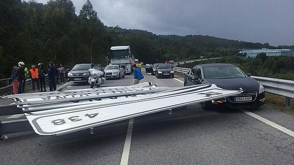 Coches parados ante el cartel. 