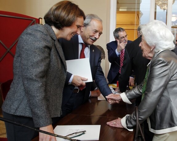 Teresa Sanjurjo y Wenceslao López saludan a una mujer durante la presentación del sello de la Princesa Leonor. 