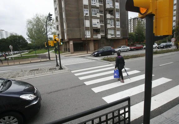 Semáforo como el que se quiere erradicar, en verde para peatón y ámbar para los coches. 