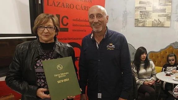 Teresa Escudero y Belarmino García, con el libro que la fábrica realizó para sus trabajadores, ayer, en el Café Macondo. 