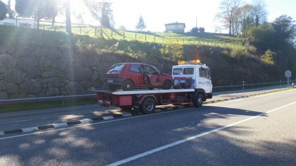 El turismo accidentado es trasladado por una grúa. 