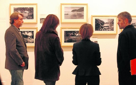 Nacho Carballo -a la derecha- y a los comisarios de la muestra observan las fotografías. 