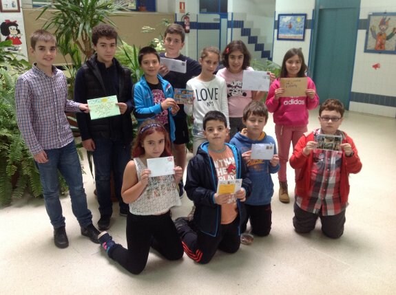 Los alumnos del Vallín muestran las postales recibidas de niños polacos y franceses. 