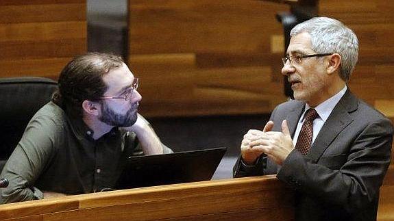 Los portavoces parlamentarios de Podemos e IU, Emilio León y Gaspar Llamazares, dialogan al término de la sesión plenaria de ayer en la Junta General del Principado. 