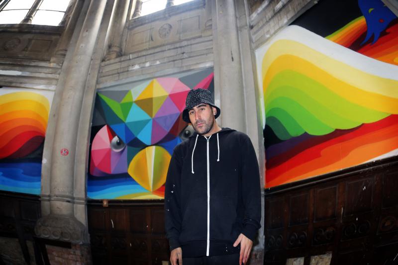 'Okuda' posa delante de uno de sus murales.