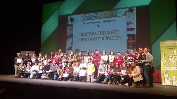 Los alumnos premiados y los representantes de los colegios participantes, en el escenario de la Laboral tras recoger los premios. 