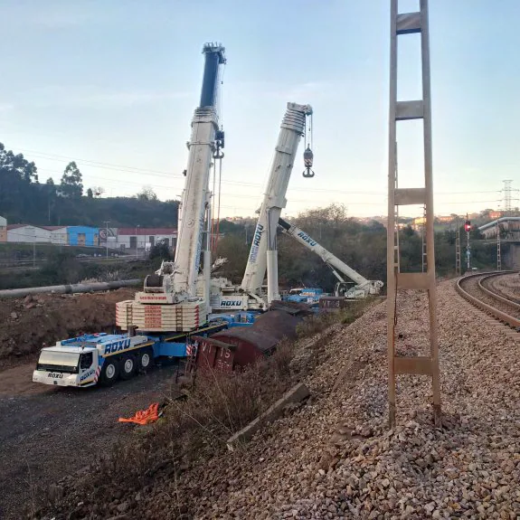  Detalle del vagón, con arrabio fundente en su interior.  Las tres grúas, preparando el izado del tren 'torpedo'. 