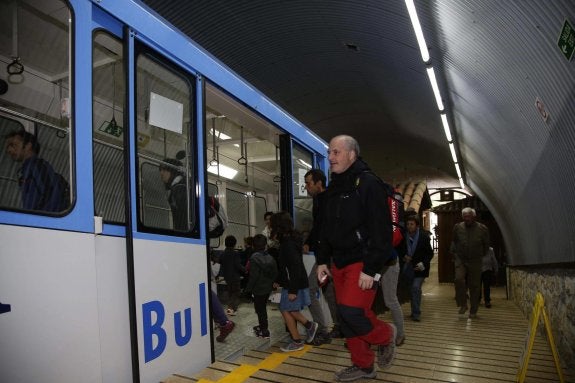 Un grupo de visitantes accede al funicular de Bulnes, el único medio de transporte que da acceso a esta aldea situada en el Parque Nacional de los Picos de Europa. 