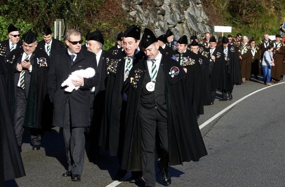 Las cofradías, acompañados de futuros cofrades como Tomás Guasch (en el centro) desfilaron por La Foz, con 'bebé' incluido.