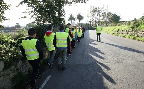 Los niños del Xove caminan por una vía sin arcén. 