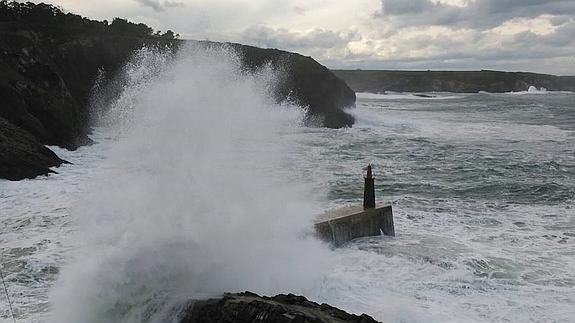 Grandes olas rompen contra los diques del puerto de Viavélez.