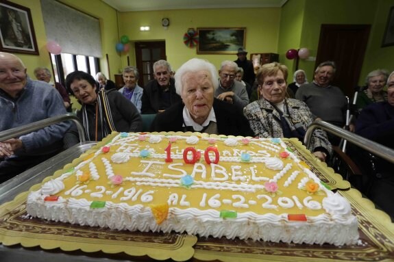 Isabel sopla las velas de la tarta en su 100 cumpleaños. 