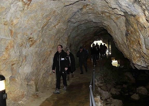 En primer plano, el guía que introdujo al primer grupo de visitantes de la temporada ayer en Tito Bustillo, en los primeros metros de la cueva. 