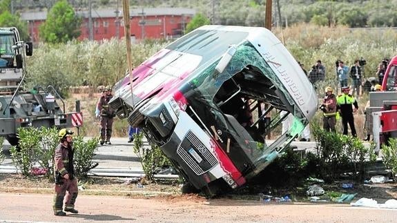 Efectivos del cuerpo de bomberos en el momento de levantar el autocar perteneciente a la empresa de Mollet del Vallès.