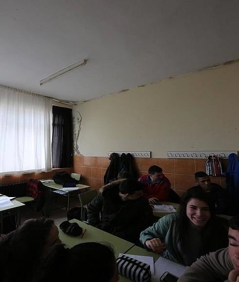 Alumnos en una de las aulas del IES de La Luz, con humedades y grietas en las paredes.