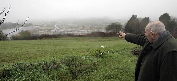 Alfredo García, uno de los vecinos de Campañones cuya vivienda está más próxima al vertedero, señala las instalaciones de Cogersa en el valle de la Zoreda. 