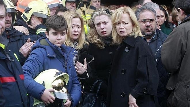 El hijo pequeño del bombero fallecido, junto a su madre, a la derecha, y otros familiares.