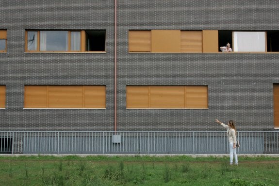 Una vecina señala la ventana de la vivienda en la que fue encontrado cosido a puñaladas el cadáver. 