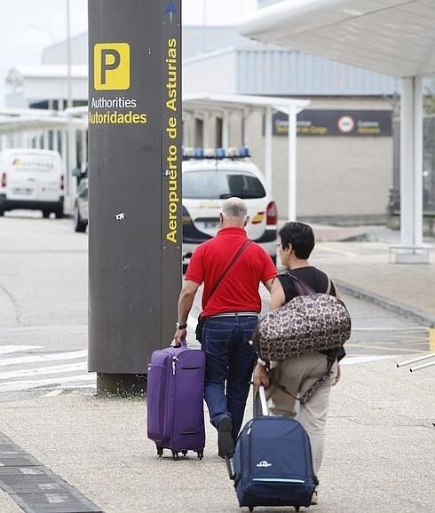 Dos pasajeros con sus maletas en el Aeropuerto de Asturias