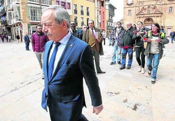 El alcalde cruza la plaza ante la protesta de los trabajadores. 