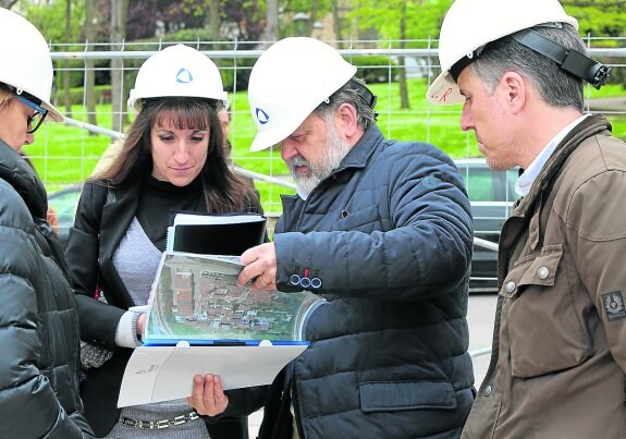 El gerente de Ruasa muestra a la subdirectora y a la alcaldesa los planos del edificio. 
