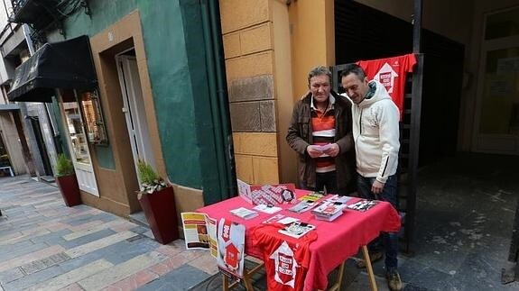 Dos de los usuarios del albergue, ayer en la mesa informativa colocada a la puerta.