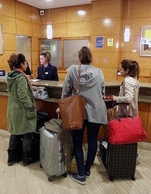 Tres turistas, a la llegada a su hotel en Oviedo. 