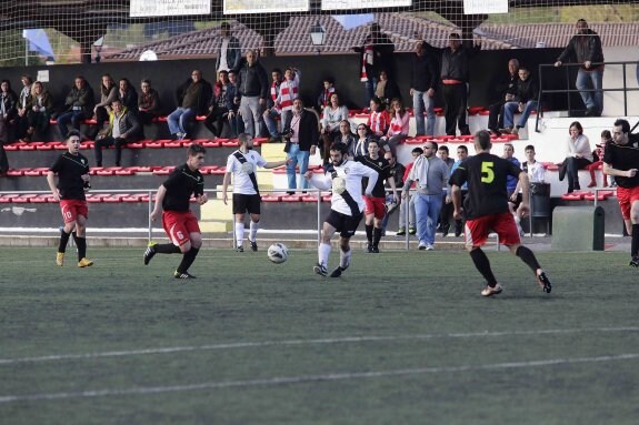 Tres centrocampistas del Ujo intentan arrebatar el esférico a un jugador del Arenas del Sella. 