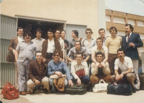 Equipo del Grupo Covadonga que ascendió en Gavá en 1976, con los técnicos Antonio Oliva y Falo Méndez, a la izquierda, posan a la entrada del pabellón de la citada localidad de Barcelona. 