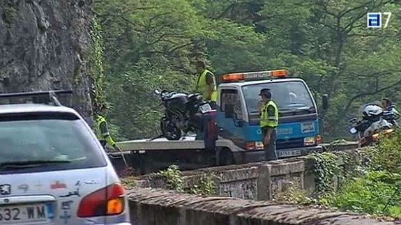 Imagen de los trabajadores de la grúa retirando la moto.