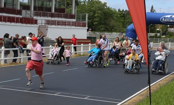 Miembros de varios colectivos y asociaciones de discapacitados, durante la carrera en el velódromo de Las Mestas. 