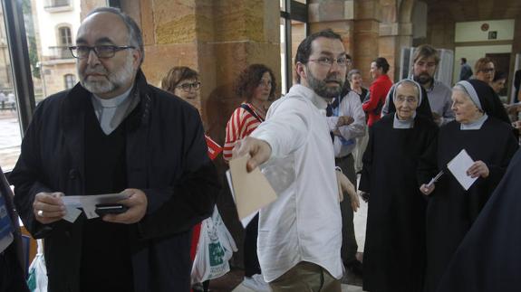 El arzobispo de Oviedo, Jesús Sanz Montes, en la cola para votar, por delante del portavoz parlamentario de Podemos, Emilio León, y dos monjas, en la Facultad de Psicología de Oviedo.