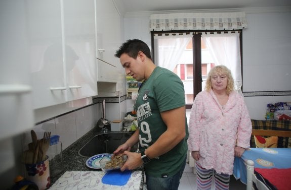 Hugo F. S. prepara la comida a su madre, Ana María, en su domicilio. 