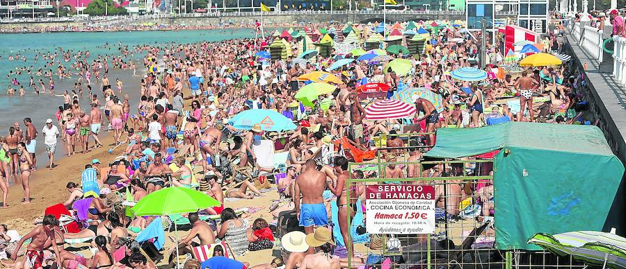 La playa de San Lorenzo, abarrotada. Tras vivir el lunes el día de julio más caluroso de la historia, con 34,4 grados de máxima, Gijón registró ayer 25,8 grados.