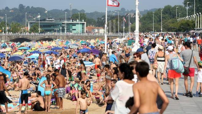 Las altas temperaturas llenaron las playas asturianas. En la imagen, paseo y playa de San Lorenzo, en Gijón.