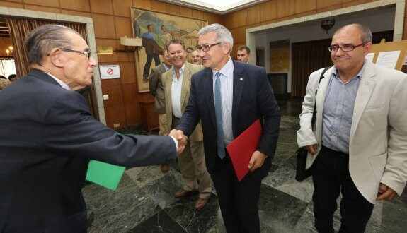 El rector, Santiago García, saluda a Juan Velarde (izda), presidente de los cursos de La Granda. 