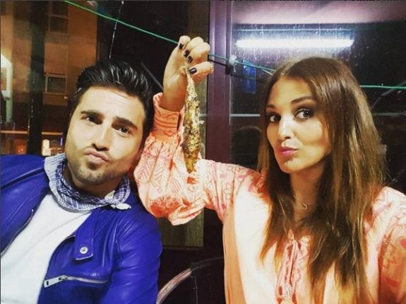 Bustamente -con el pañuelo típico de las fiestas- y Paula, mostrando una sardina. 