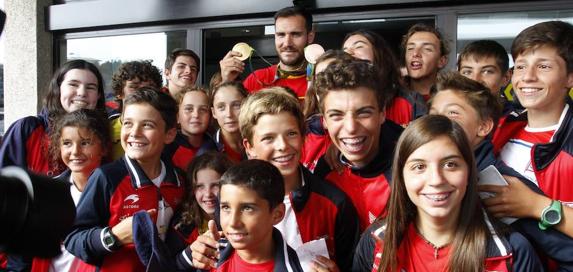 Saúl Craviotto enseña las medallas logradas en los Juegos de Río en presencia de los jóvenes del Grupo Covadonga. 