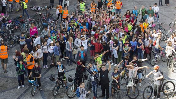 Los alumnos de Primaria gijoneses saludan con sus bicicletas desde la plaza Mayor.