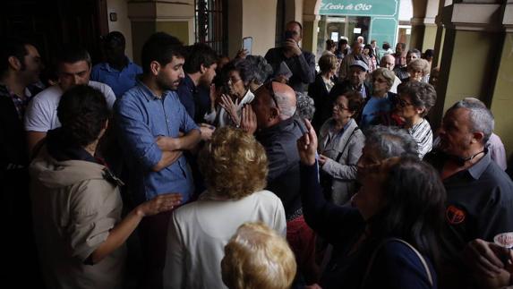Un grupo de vecinos increpa a los concejales de Somos José Alberto Caveda, María Rosario Hernández (de espaldas) y Elías López, con camiseta blanca. 