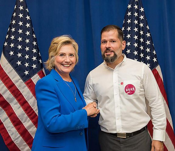Hillary Clinton, dándole la mano a Espina, que vive desde hace varios años en Carolina del Norte.