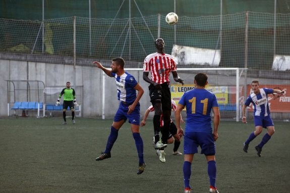 Dudi salta con Saha en el partido de Siero. 