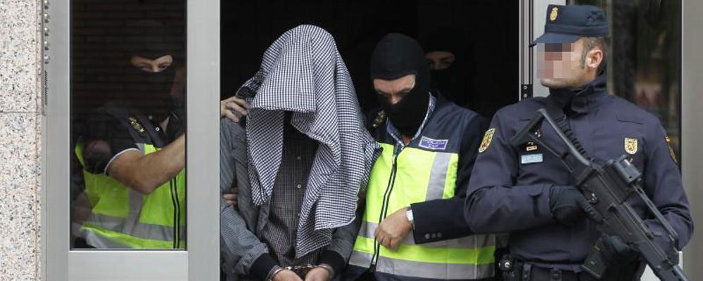 El detenido, a la salida de su domicilio, custodiado por la Policía.