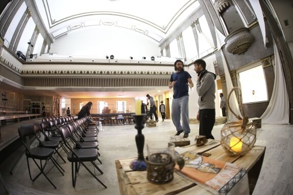 El corazón del Arango, ahora sin escenario ni patio de butacas, se llena de sillas y gradas metálicas para la función, mientras los actores ensayan.                        