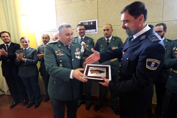 El brigada de la Guardia Civil y jefe de puesto de Noreña, Gonzalo Lorenzo, entrega la placa conmemorativa a Eduardo García, jefe de la Policía Local . 